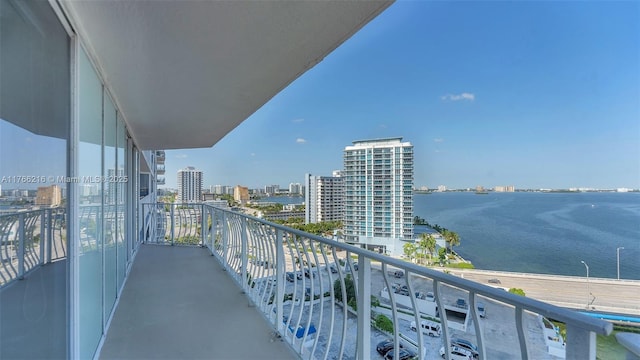 bedroom featuring access to exterior, floor to ceiling windows, and a water view