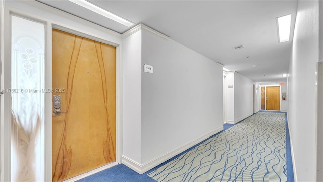 hall with baseboards and carpet floors