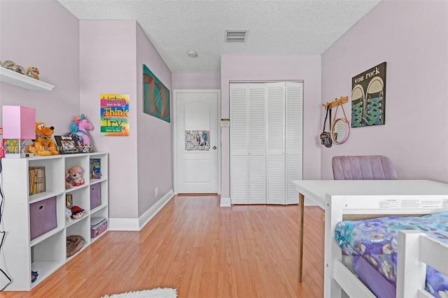 772 NW 132nd Ave, Plantation, FL 33325 - bedroom with baseboards, visible vents, light wood-style floors, a closet, and a textured ceiling