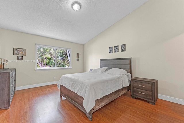 772 NW 132nd Ave, Plantation, FL 33325 - bedroom featuring vaulted ceiling, baseboards, light wood finished floors, and a textured ceiling