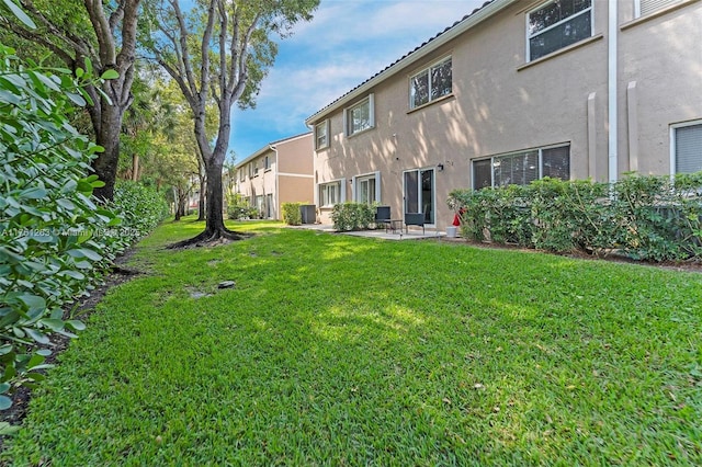 772 NW 132nd Ave, Plantation, FL 33325 - rear view of house with stucco siding, a lawn, and a patio