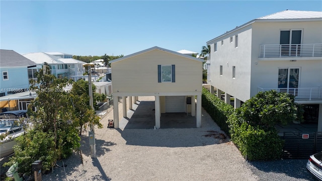 view of property featuring gravel driveway, a carport, and a residential view