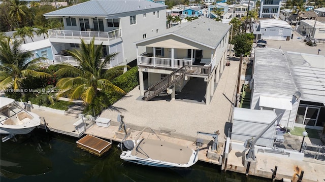 rear view of property featuring a water view and stairs