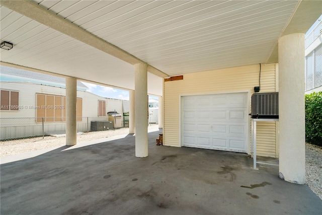 garage with a carport and fence