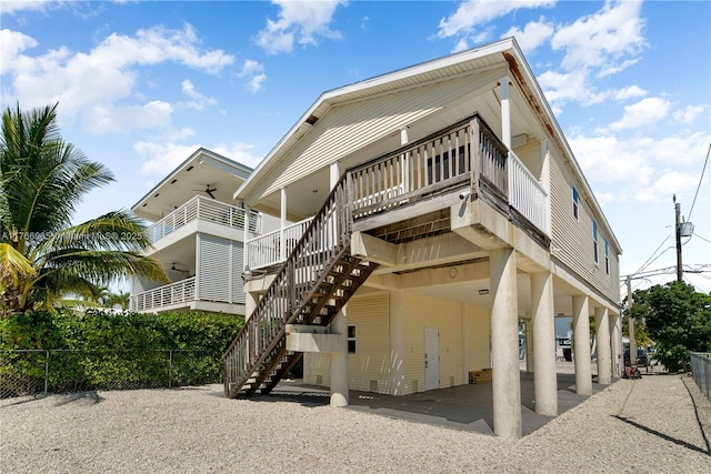 view of property featuring a carport, stairway, driveway, and fence