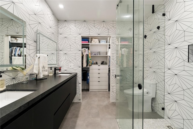full bathroom featuring tile patterned flooring, a shower stall, tile walls, and a sink