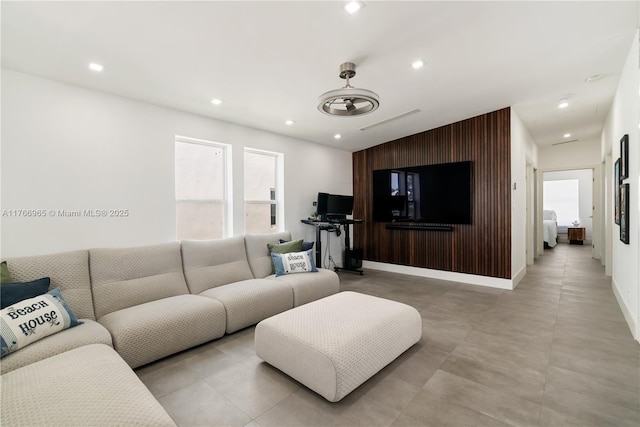living room featuring recessed lighting, baseboards, and an accent wall