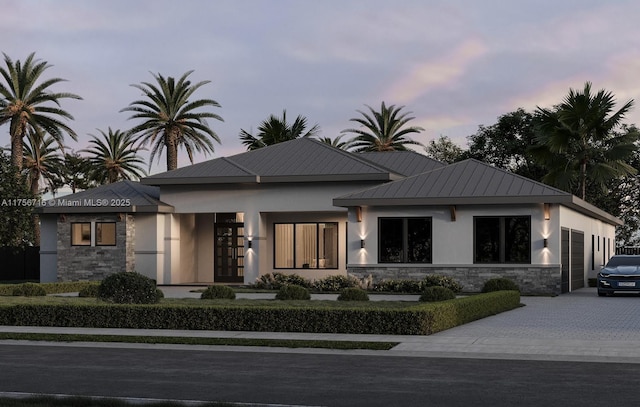 view of front of house with driveway, stucco siding, and stone siding