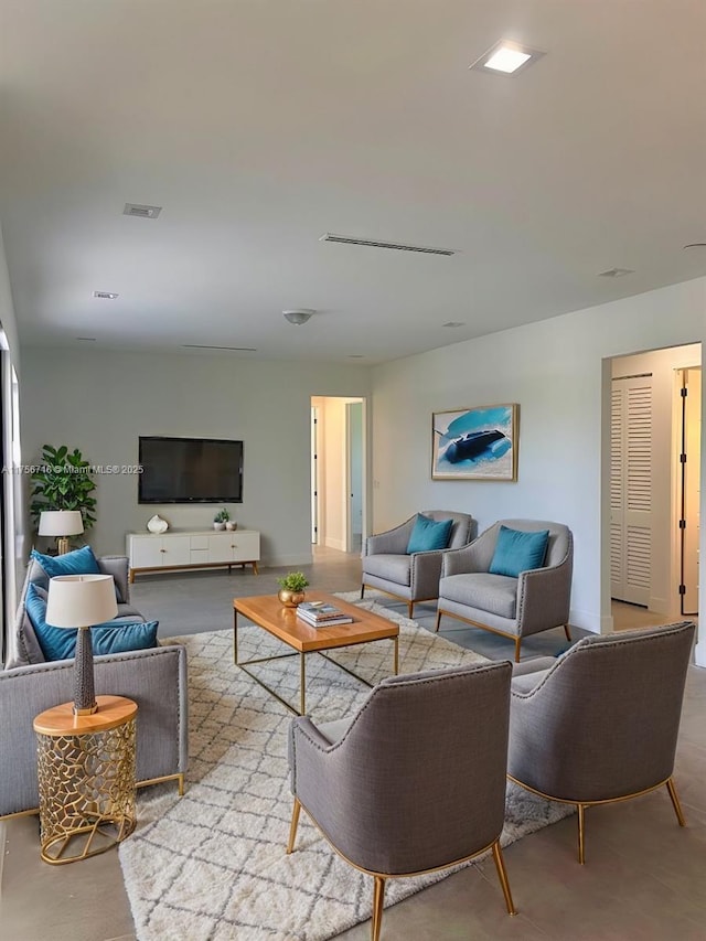 living area featuring concrete flooring and visible vents