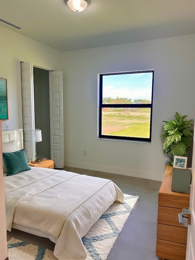 bedroom featuring concrete floors, visible vents, and baseboards