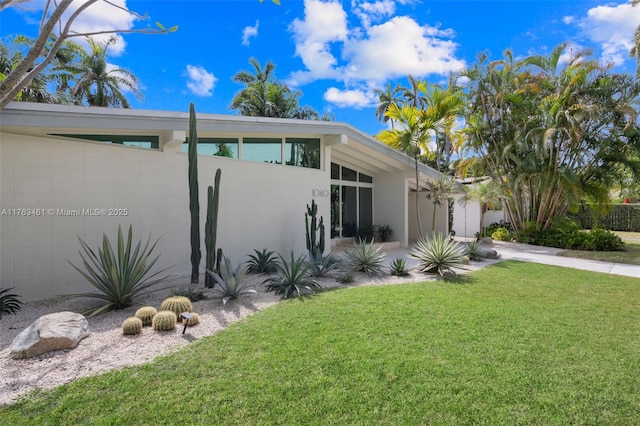 1040 NE 85th St, Miami, FL 33138 - view of front of house with a front yard, a garage, concrete block siding, and concrete driveway