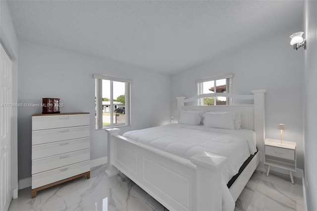 bedroom with marble finish floor, a textured ceiling, baseboards, and multiple windows