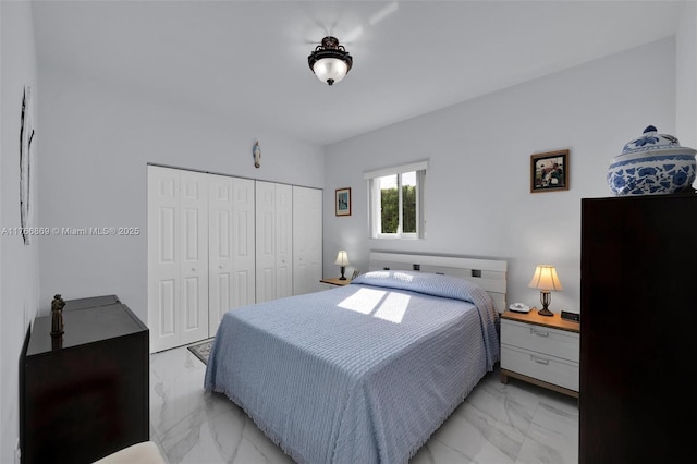 bedroom with a closet and marble finish floor