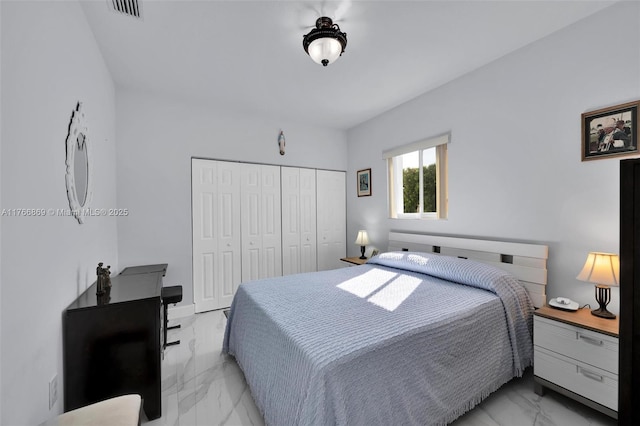 bedroom with visible vents, marble finish floor, and a closet