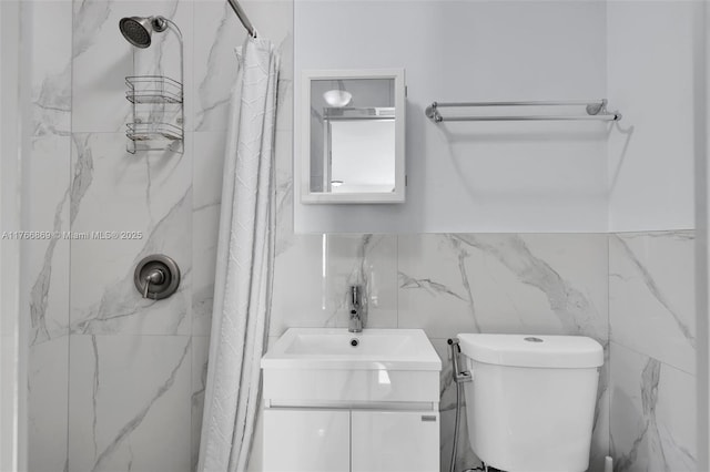 full bath with a shower with curtain, tile walls, vanity, and toilet