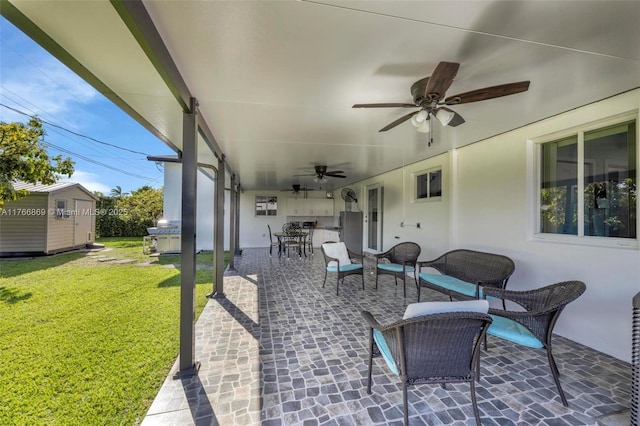 view of patio / terrace with an outbuilding, area for grilling, outdoor dining area, ceiling fan, and a storage unit