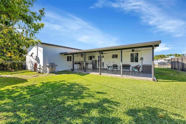 back of house featuring stucco siding, a lawn, a patio, fence, and ceiling fan