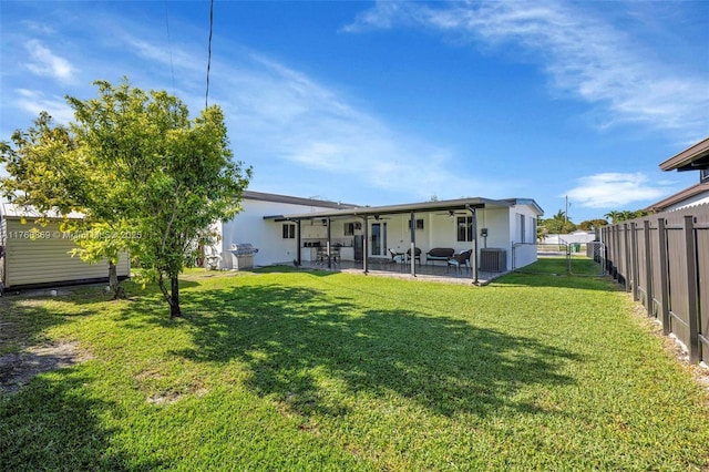 back of house featuring a patio area, a lawn, cooling unit, and a fenced backyard
