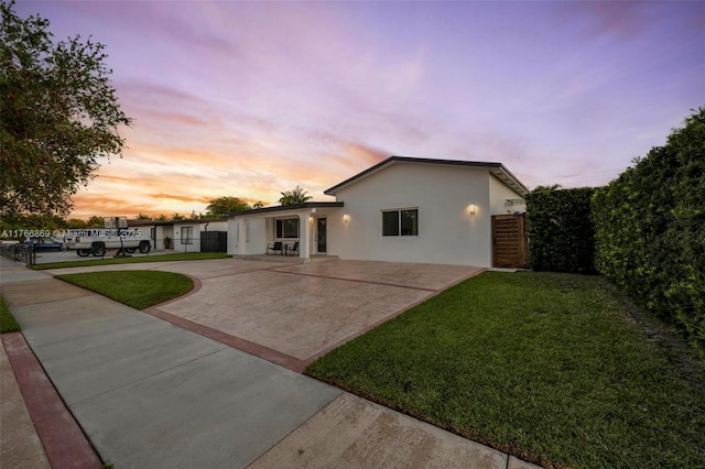 single story home with stucco siding, a patio area, a front lawn, and fence