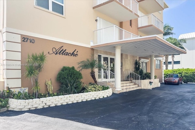 view of exterior entry with driveway and stucco siding