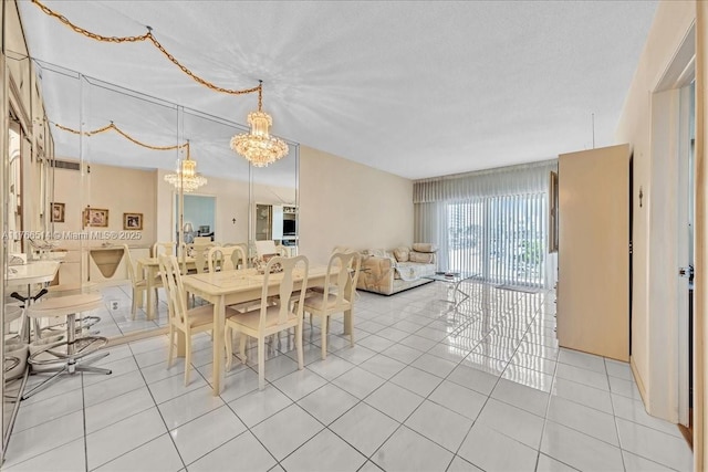 dining room featuring an inviting chandelier, light tile patterned floors, and a textured ceiling