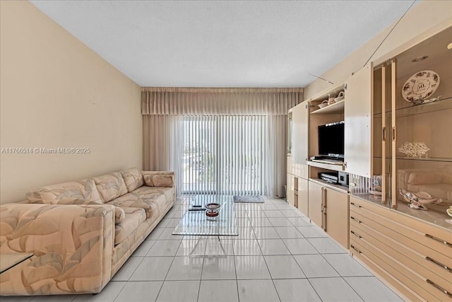 living area featuring a textured ceiling and light tile patterned flooring