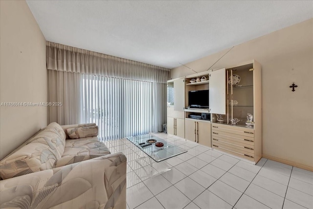 living room featuring light tile patterned flooring and baseboards