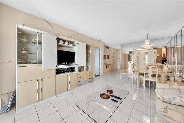 living room featuring light tile patterned floors, visible vents, and an inviting chandelier
