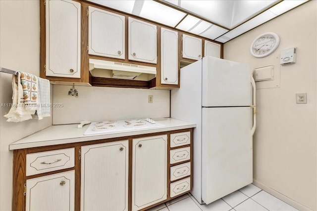 kitchen featuring under cabinet range hood, white appliances, light tile patterned floors, and light countertops