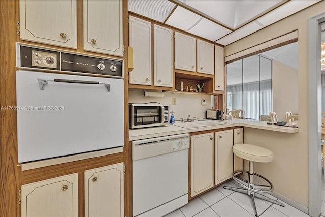 kitchen featuring white appliances, light tile patterned floors, open shelves, a sink, and light countertops