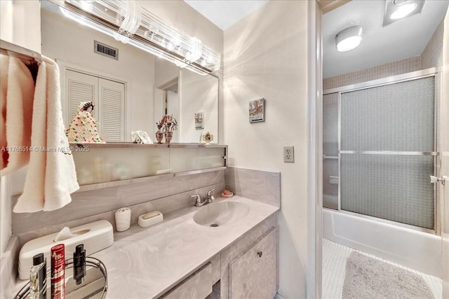 bathroom with vanity, visible vents, and enclosed tub / shower combo