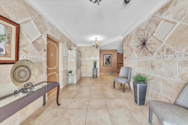 2710 S Ocean Dr Unit 402, Hollywood, FL 33019 - hallway featuring tile walls, a chandelier, ornamental molding, a textured ceiling, and tile patterned floors