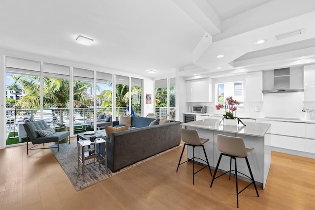 living room with recessed lighting, light wood-type flooring, visible vents, and floor to ceiling windows