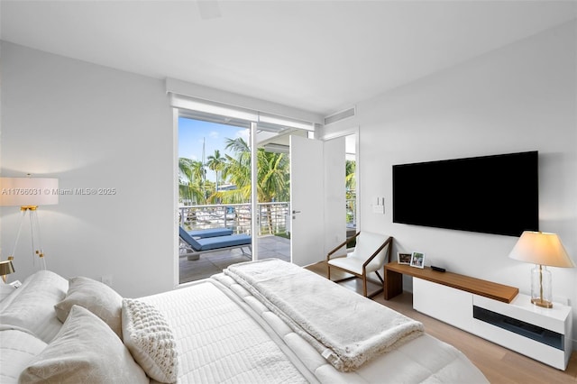 bedroom featuring wood finished floors and access to exterior