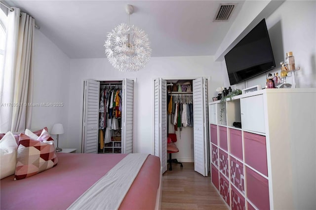 14016 SW 160th St, Miami, FL 33177 - bedroom with an inviting chandelier, wood finished floors, visible vents, and multiple closets