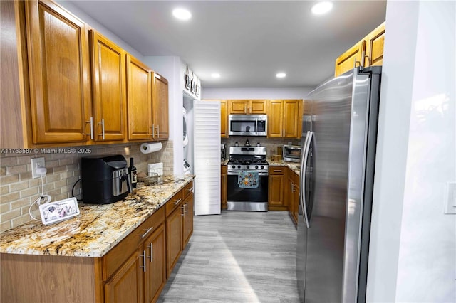 14016 SW 160th St, Miami, FL 33177 - kitchen with light wood finished floors, decorative backsplash, stainless steel appliances, and brown cabinetry
