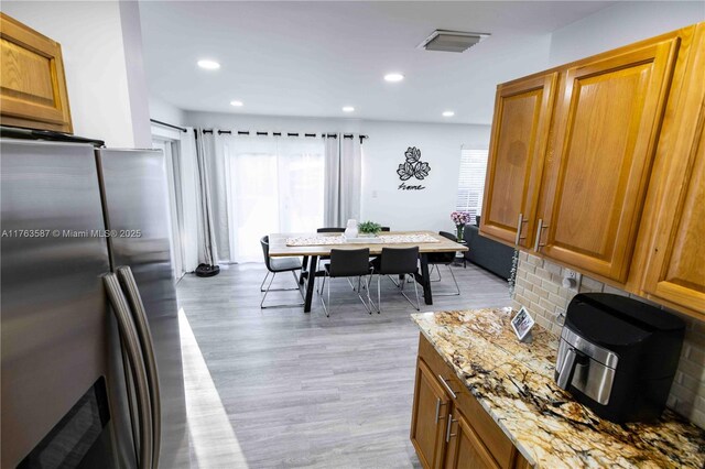 14016 SW 160th St, Miami, FL 33177 - kitchen with light wood-style flooring, stainless steel refrigerator with ice dispenser, a wealth of natural light, and brown cabinets