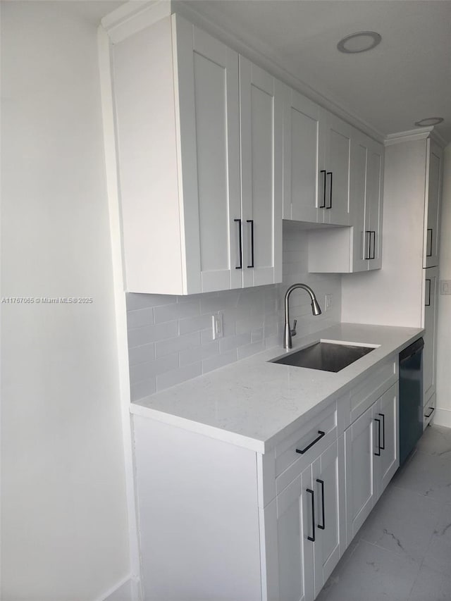 kitchen with marble finish floor, a sink, light stone counters, backsplash, and dishwasher