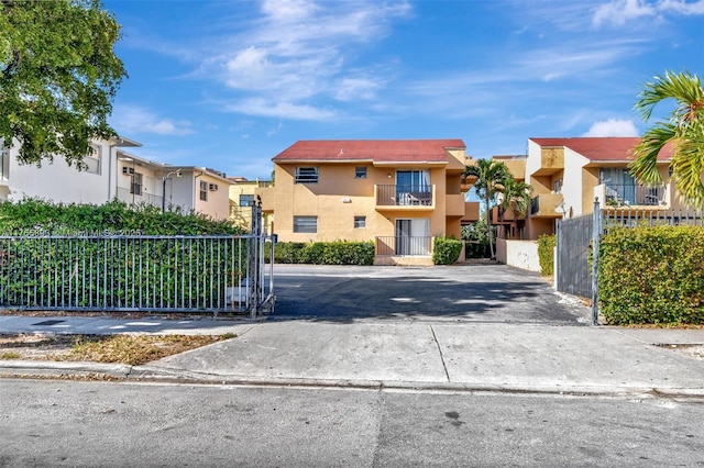 exterior space with a residential view, concrete driveway, and a gated entry
