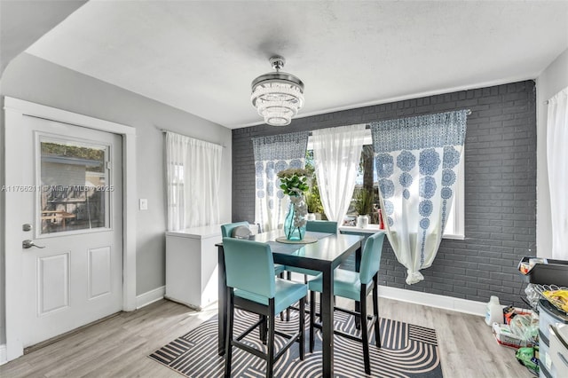 2813 SW 67th Ln, Miramar, FL 33023 - dining area featuring an inviting chandelier, brick wall, baseboards, and light wood finished floors