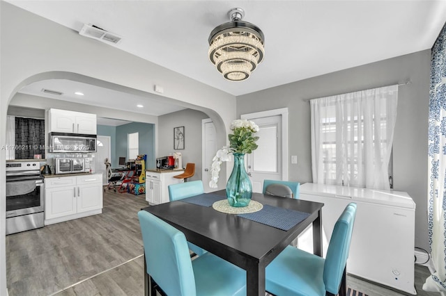 2813 SW 67th Ln, Miramar, FL 33023 - dining room with recessed lighting, visible vents, arched walkways, and light wood-style flooring