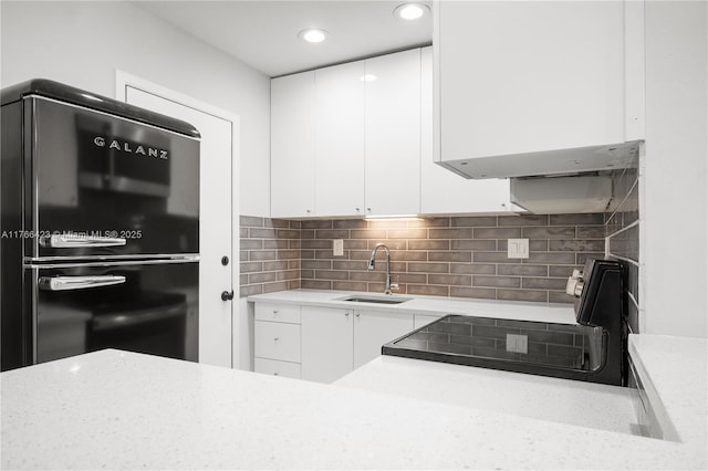 3040 NE 16th Ave Unit 104, Oakland Park, FL 33334 - kitchen featuring freestanding refrigerator, white cabinets, range with electric cooktop, a sink, and recessed lighting
