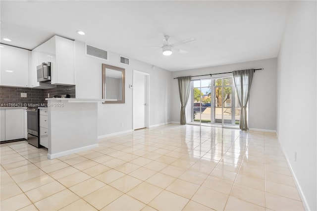 3040 NE 16th Ave Unit 104, Oakland Park, FL 33334 - kitchen featuring stainless steel appliances, ceiling fan, white cabinetry, tasteful backsplash, and open floor plan