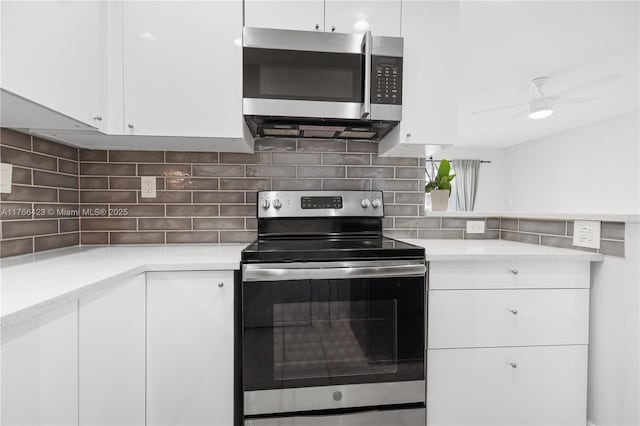3040 NE 16th Ave Unit 104, Oakland Park, FL 33334 - kitchen with stainless steel appliances, white cabinets, backsplash, and ceiling fan