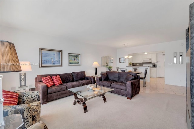 living room with light carpet and an inviting chandelier