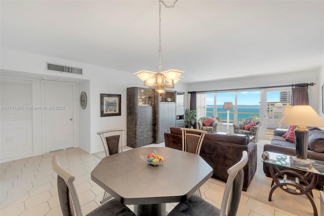 dining room with an inviting chandelier, light tile patterned floors, and visible vents