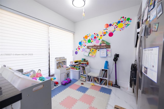 rec room with baseboards and marble finish floor