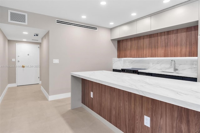 5255 Collins Ave Unit 9B, Miami Beach, FL 33140 - kitchen with modern cabinets, white cabinetry, light stone countertops, recessed lighting, and stove