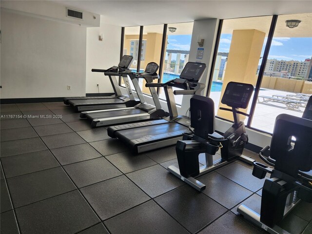 4242 NW 2nd St Unit 1202, Miami, FL 33126 - workout area with a wall of windows, baseboards, and visible vents