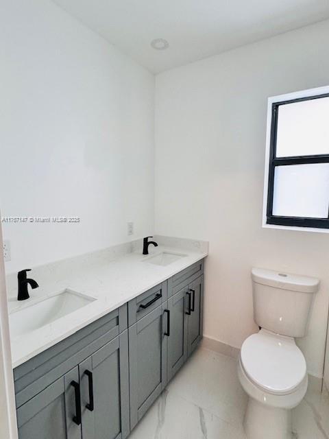 11730 NW 3rd Ave, Miami, FL 33168 - bathroom featuring marble finish floor, toilet, baseboards, and a sink